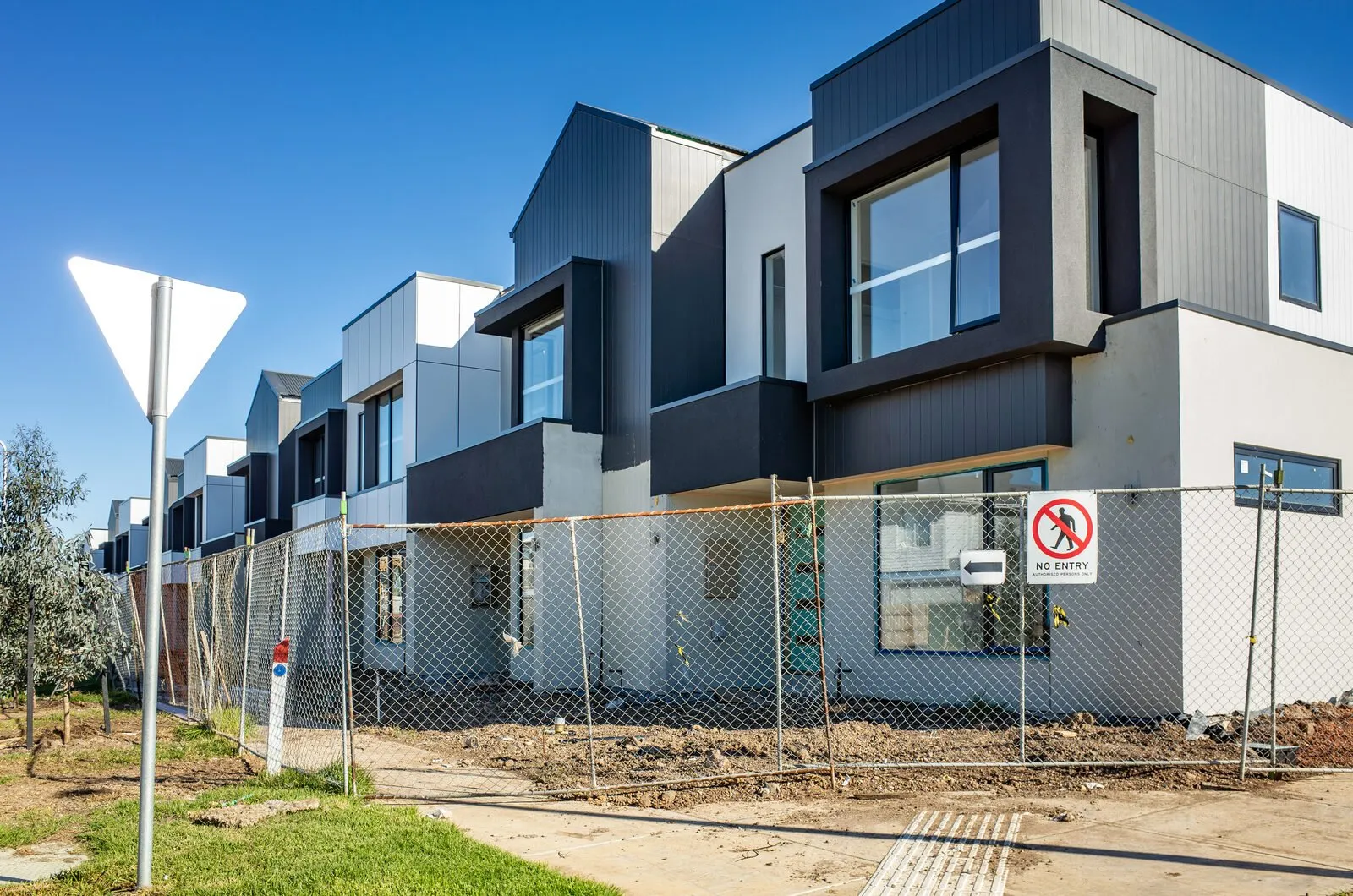 Two-storey narrow block home under construction with a built-to-boundary wall on a Brisbane infill lot