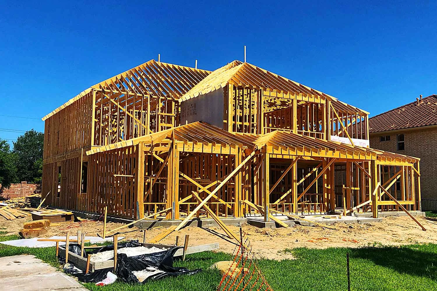 Timber frame of a new home standing on a cleared suburban block
